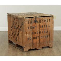 an old wooden crate sitting on top of a hard wood floor next to a wall