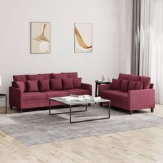 a living room with two red couches and a coffee table in front of it