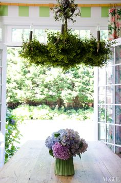 a vase filled with flowers sitting on top of a table under a chandelier