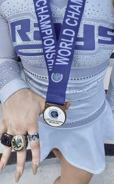 a woman wearing a blue ribbon around her neck and ring on her left hand, with the words world champion written on it