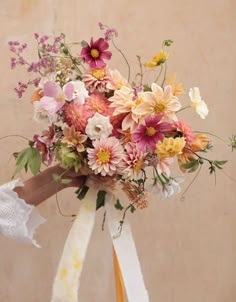 a bouquet of flowers with ribbons tied around it