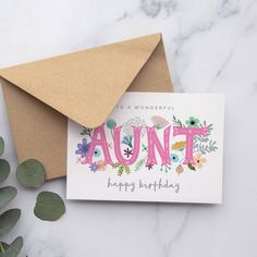 an envelope and card with the word,'happy birthday'written in floral letters