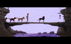 two dogs are walking across a bridge over water with people on it and one dog is standing on the edge