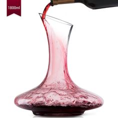 a red wine being poured into a glass in front of a white background with the label below it