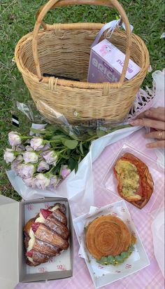 there is a basket with bread and pastries on the table next to it, along with other food items