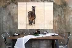 a brown horse standing on top of a grass covered field next to a wooden table