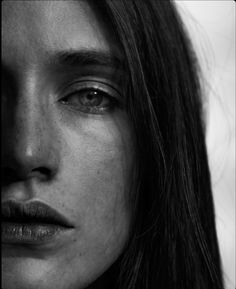 black and white photograph of a woman with freckles on her face looking at the camera