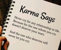 a person holding a book with the words karma says on it and an open notebook in front of them