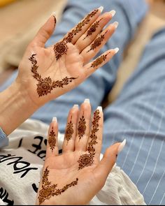 two hands with hendi designs on them