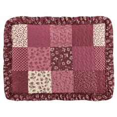 a red and white patchwork quilted placemat on a white background with pink flowers