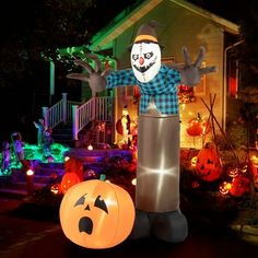 an inflatable scarecrow and jack - o'- lanterns are on display