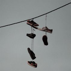 several pairs of shoes hanging from a wire