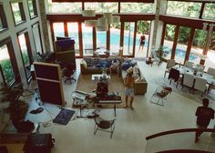 a living room filled with lots of furniture next to a swimming pool on top of a floor