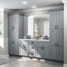 a large bathroom with gray cabinets and marble counter tops