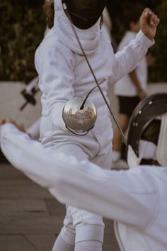 a person dressed in white and holding a stick