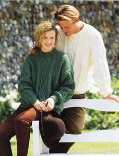 a man and woman sitting on a white bench