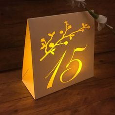 a card with the number twenty five on it and flowers in vase next to it