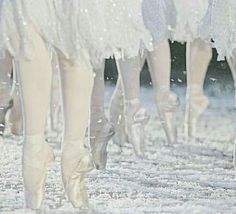 several pairs of ballet shoes are shown on the snow - covered ground, with their feet in the air