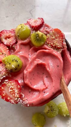 a bowl filled with fruit and topped with kiwis, strawberries and other fruits