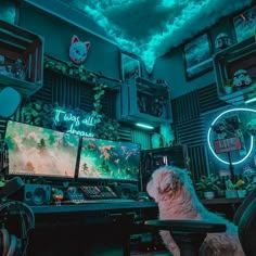 a dog sitting in front of a computer desk with a video game on the monitor