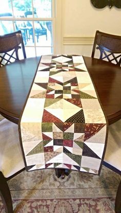 a dining room table with a quilted table runner on it's centerpiece