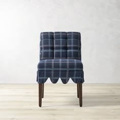 an upholstered chair with scalloped legs and a blue checkered seat cover