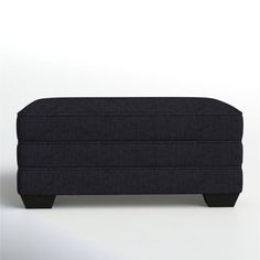 an upholstered footstool on a white background