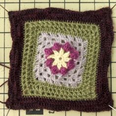 a crocheted square with a flower on it