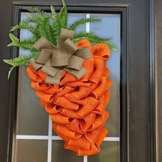 an orange burlocked wreath hanging on the front door