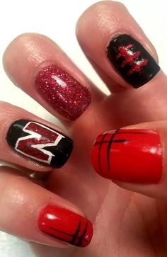 someone has red and black nail polish on their nails