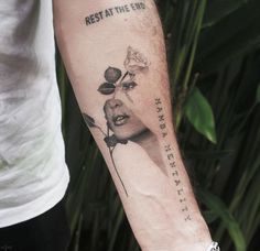 a man with a rose tattoo on his arm that says rest at the end, he has faith