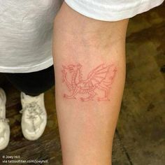 a small red dragon tattoo on the arm