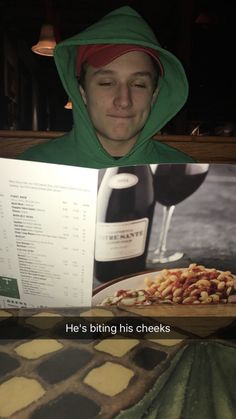 a man in a green hoodie is reading a book with food on it and the caption reads he's biting his cheeks