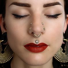 a close up of a woman with piercings on her nose