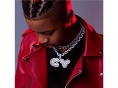 a young man wearing a red leather jacket and silver chain necklace with mickey mouse pendant