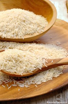 two wooden spoons filled with rice on top of a plate