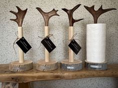 three wooden vases with fake antlers in them sitting on a shelf next to a paper towel