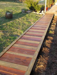 a wooden walkway in the middle of a yard