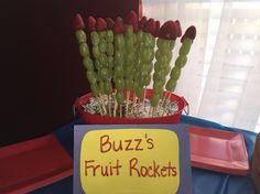 a sign that says buzz's fruit rockets on it next to some strawberries