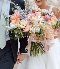 the bride and groom are holding bouquets of flowers