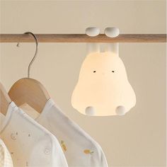 a baby's bib hanging from a wooden rail next to a light fixture