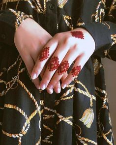 a woman's hands with hennap on her hand and red flowers painted on them