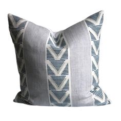 a blue and white pillow with an arrow pattern on the front, sitting against a white background