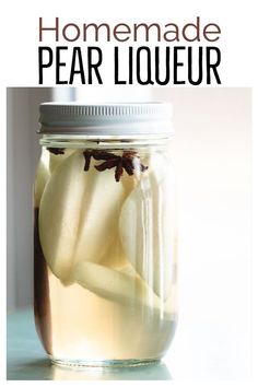 a jar filled with liquid sitting on top of a table next to an apple slice