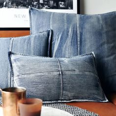 two blue denim pillows sitting on top of a couch