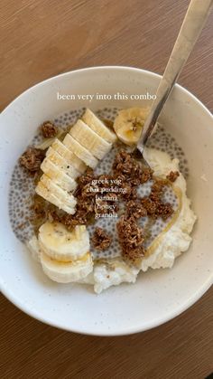 a bowl filled with bananas and granola on top of a wooden table