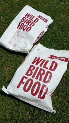 two bags of wild bird food laying on the grass