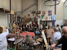 an artist's studio filled with people working on paintings