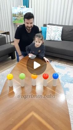 a man playing with a child in front of a table that has candles on it