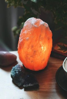 a table topped with rocks and a light on top of it next to a cup